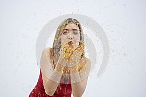 Close up of young Asian woman blowing confetti