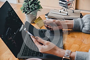 Close up young asian woman holding credit card and using mobile phone. Businesswoman working at home. Online shopping, e