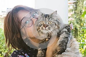 Close up of young Asian woman playing with her persian cat