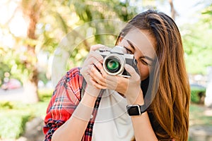 Close up of young Asian woman snap her camera outdoor and enjoyed her city lifestyle on weekend.
