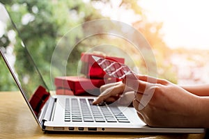 Close up ,Young asian woman typing laptop keyboard and holding credit card at coffee shop with online shopping or internet banking