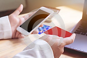 Close up ,Young asian woman typing mobile phone and holding credit card at home shop with online shopping