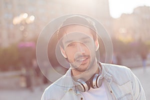 Close up of a young attractive brunete guy, walking in the city