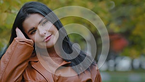 Close-up young attractive elegant pensive dreamy woman standing in autumn park portrait hispanic girl model posing