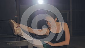 Close Up of Young Ballerina Stretching at Barre in Sunny Dance Studio