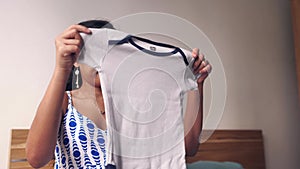 Close up of a young beautiful Asian mother folding and preparing clothes for baby.