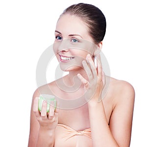 Close-up young beautiful face of girl applying moisturize cream photo