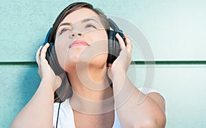 Close-up of young beautiful girl enjoying music on headphones