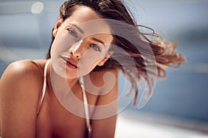 Close-up of a young beautiful girl posing for a photo while is taking a sunbath. Summer, sea, vacation