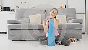 Close up of a young beautiful woman dressed in blue jogging or a fitness mat after working at home in the living room.
