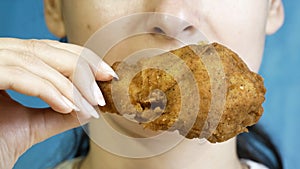 Close-up, young beautiful woman eats, fast food, chicken nuggets, wings and chicken leg