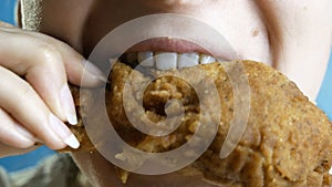 Close-up, young beautiful woman eats, fast food, chicken nuggets, wings and chicken leg