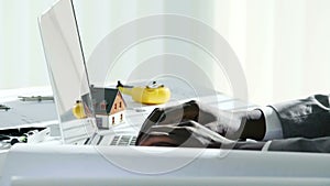 Close up of young black businessman hands typing on laptop computer keyboard in white modern office in the sunny day