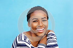 Close up young black fashion woman smiling against blue wall