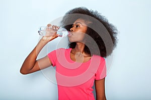 Close up young black woman drinking bottle of water