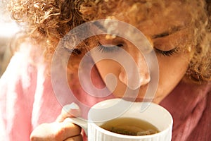 Close up young black woman drinking cup of tea