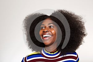 Close up young black woman laughing and looking up against gray background