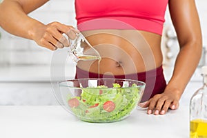 Close up of young black woman preparing vegetable salad
