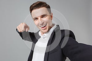 Close up of young business man in classic black suit shirt isolated on grey background. Achievement career wealth