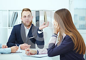 Close-up of young business people sitting at conference table. communicating.