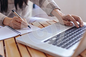 Close up young business woman hands with pen writing notes on paper. female executive sitting at table at home office. Woman`s