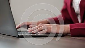 Close up of young business woman working and typing on laptop with happy on office