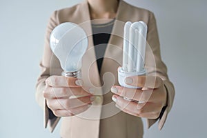 Close-up of a young businesswoman holding a light bulbs