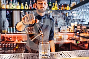 Close up of a young caucasian bearded male barista pouring coffee into Kalita Wave Dripper coffee filter. Brewing liquid after photo