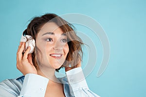 Close-up young Caucasian beautiful woman in casual clothes  on light blue background.