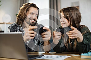 Close up of young caucasian family, holding joysticks and enjoying their free time playing new games
