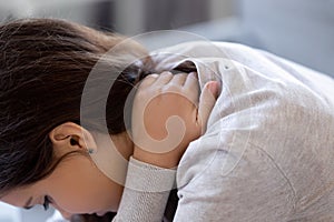 Close up young caucasian woman suffers from neck pain