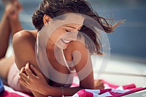 Close-up of a young cheerful girl who is in a good mood while is enjoying a sunbath. Summer, sea, vacation