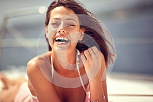 Close-up of a young cheerful girl who is spending wonderful time while is enjoying a sunbath. Summer, sea, vacation