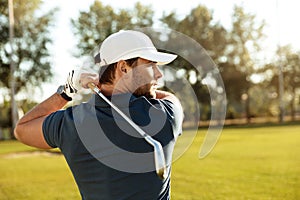 Close up of a young concentrated man shooting golf ball