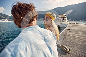 Close-up of a young couple chatting on the dock on the seaside. Love, relationship, holiday, sea