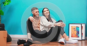 Close up of young couple in new apartment. Man and woman sitting on the floor