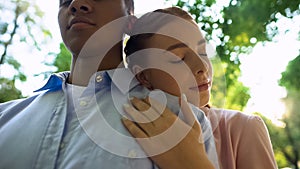 Close-up of young couple in park, teen girl leaning on boyfriends shoulder, love