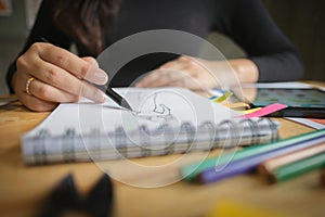 Close-up of young creative fashion designer working project at a modern home office