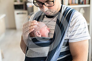 Close up of young father with his son in sling