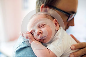 Close up of young father holding his newborn baby son