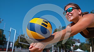 CLOSE UP: Young female beach volleyball player receives and passes the ball.