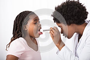 Doctor Checking His Patient`s Throat photo
