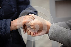 Close-up of young female hands holding senior woman hands