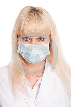 Close up of a young female nurse in mask looking at the camera
