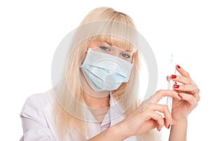 Close up of a young female nurse in a mask with a syringe