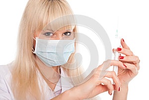 Close up of a young female nurse in a mask with a syringe