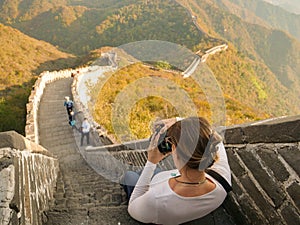 CLOSE UP: Young female photographer takes pictures of Great Wall and landscape