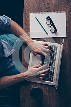 Pohľad zblízka na mladý nezávislý pracovník robiť úloha a písanie na prenosný počítač 