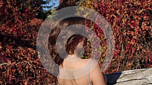 Close-up of a young girl in a beautiful evening dress walking in the autumn park