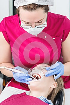 Close-up a young girl in a dentist`s chair undergoes a routine diagnosis after removing braces with cleaning and sizing